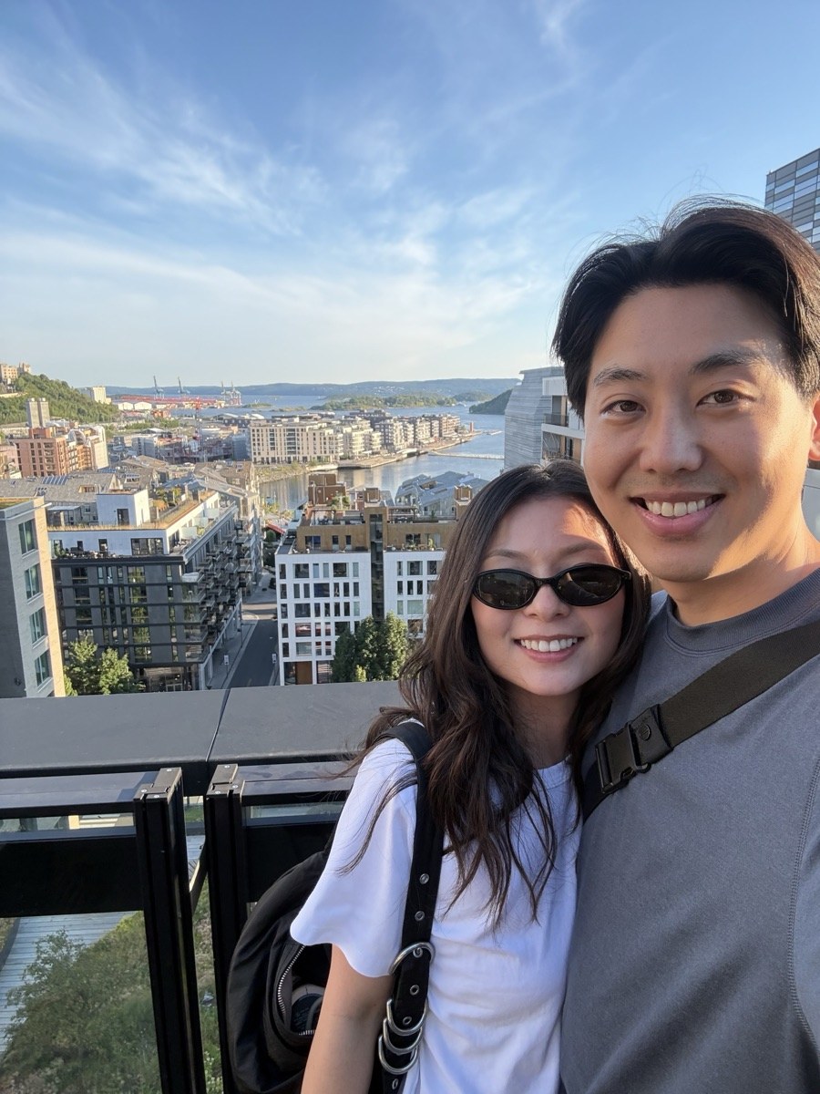 Angela and her husband on a rooftop overlooking the city